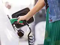 Eine Person lädt ein Elektrofahrzeug an einer Ladestation.