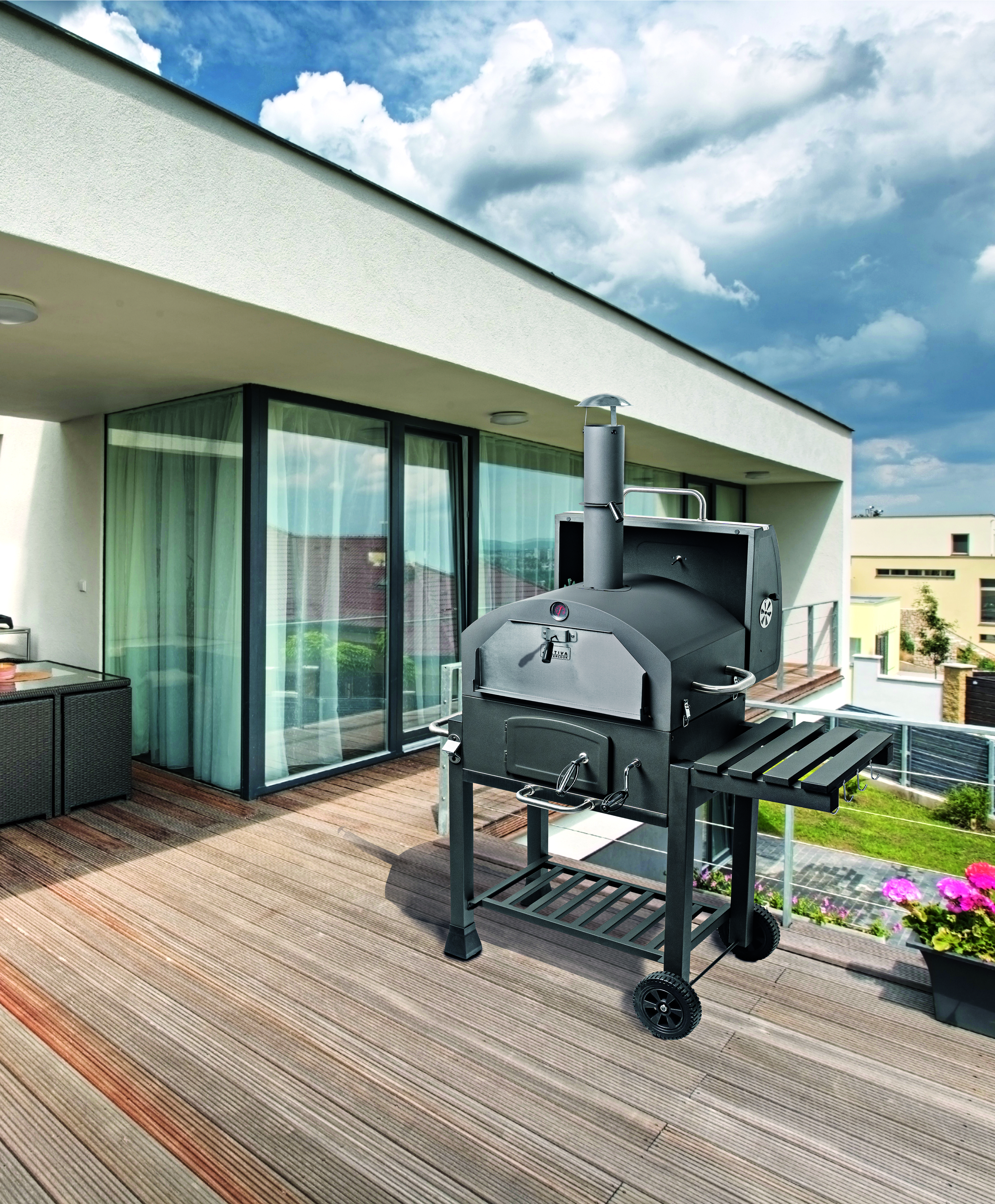 Ein schwarzer Pizza-Grill steht unbenutzt auf einer modernen Terrasse bei bewölktem Wetter.