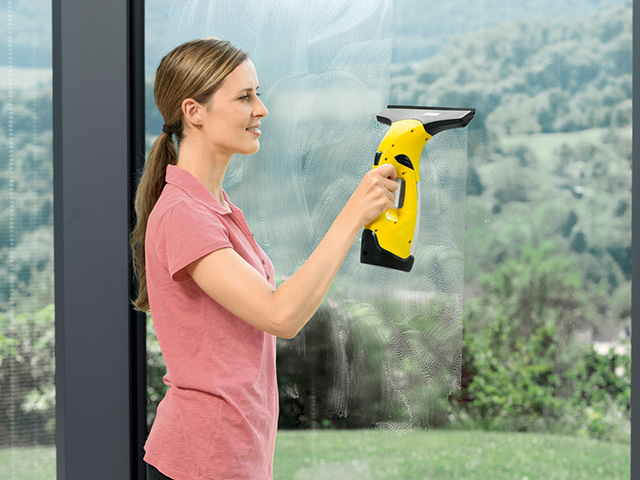 Kaercher_Fenstersauger Frau mit Kärcher Fenstersauger beim Fensterputzen