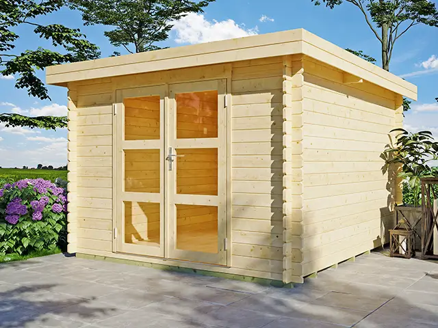 Ein hölzernes Gartenhaus steht auf einer Terrasse, umgeben von Pflanzen und Bäumen.