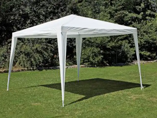 Ein weißes Zelt steht frei auf einem grünen Rasen, umgeben von Bäumen.