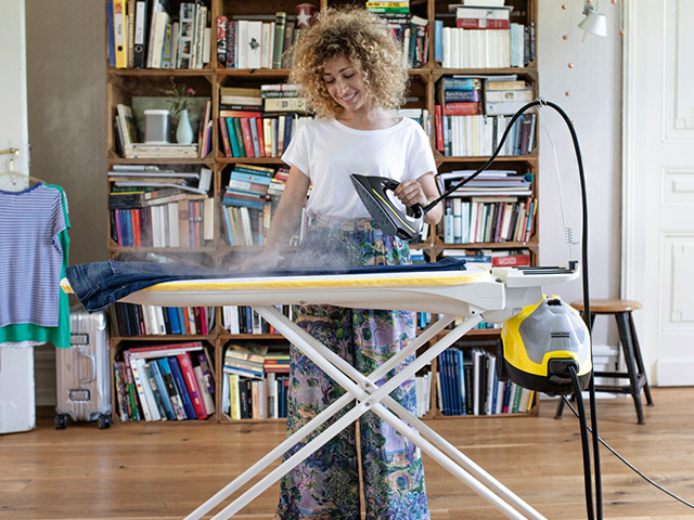 Frau mit Kärcher Dampfreiniger beim Bügeln