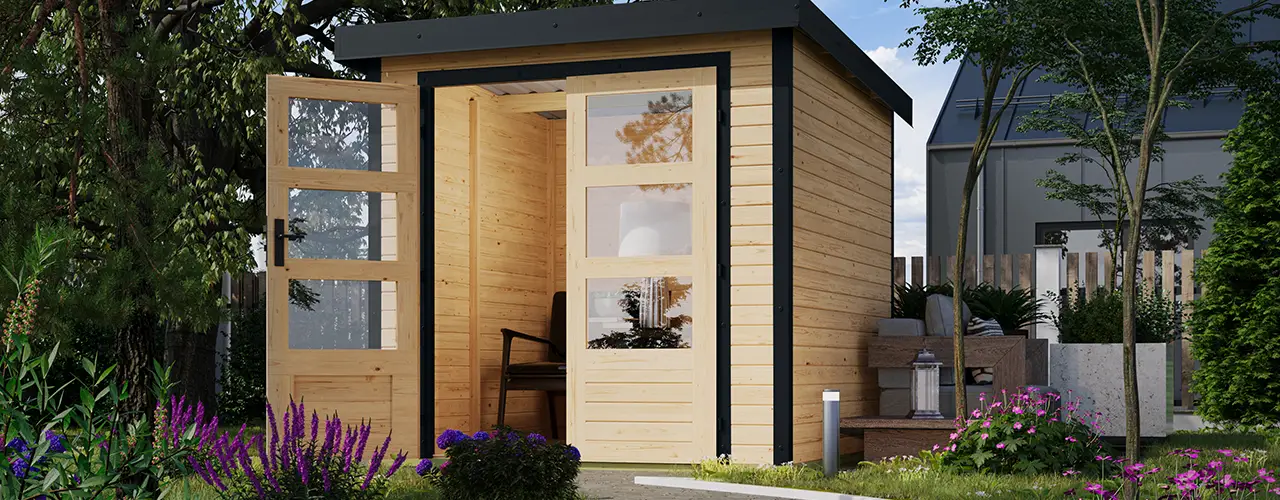 Ein Holzschuppen mit offener Glastür steht in einem blühenden, grünen Garten.