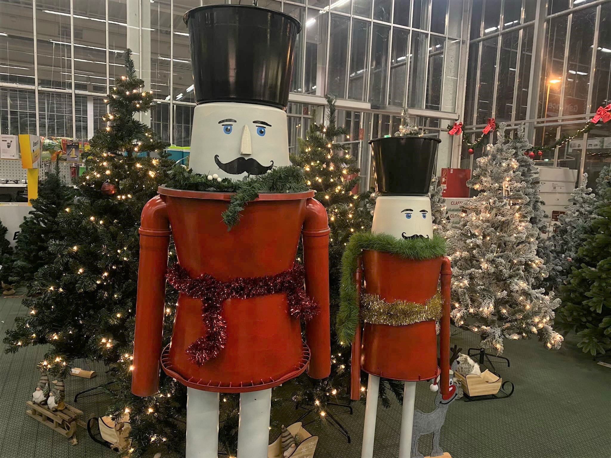 Zwei XXL Nussknacker vor beleuchteten Tannenbäumen