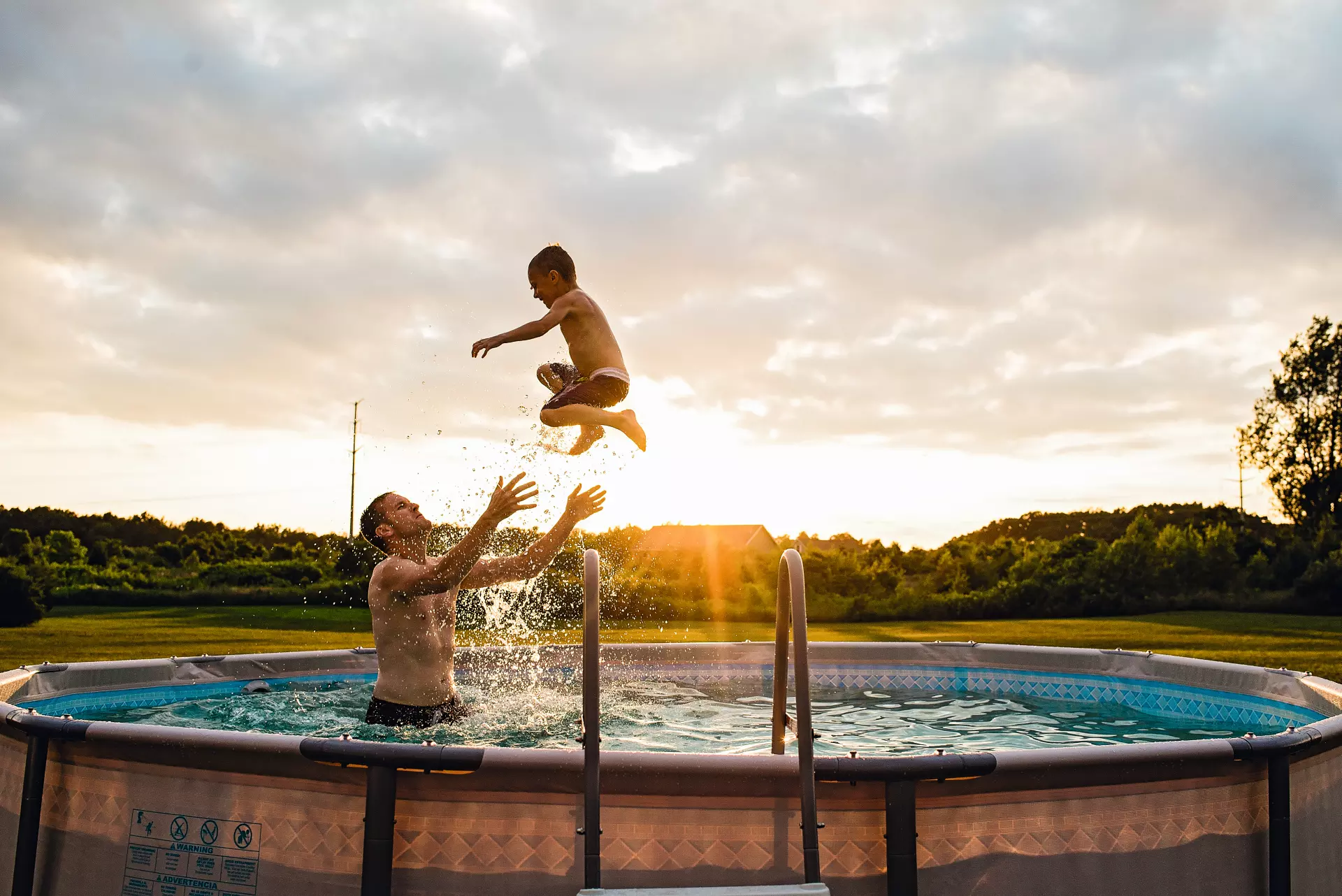 Ein Mann mit seinem Sohn im Pool