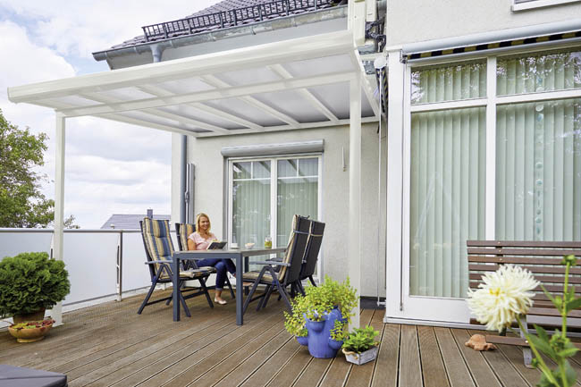 Frau sitzt unter Terrassenüberdachung