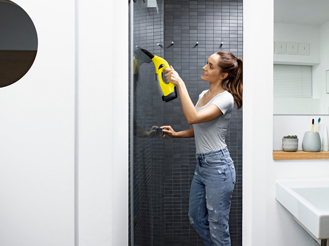Kaercher_Fenstersauger Frau mit Kärcher Fenstersauger in der Dusche
